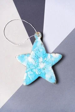Blue epoxy star on a gray background. Christmas decorations on the tree Stock Photos