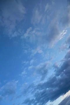 Blue evening sky with dark clouds, unusual angle of the evening sky, vertical Stock Photos