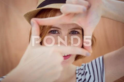 Blue eyed hipster looking through her hands Stock Photos