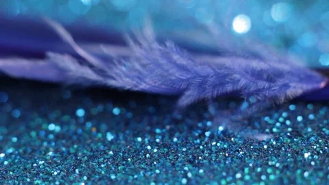 Blue feather on a blue shiny background swaying from the wind and flies away Stock Footage 124039763