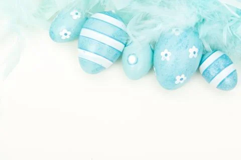 Blue feathers and decorative easter egss on a white background Foto stock