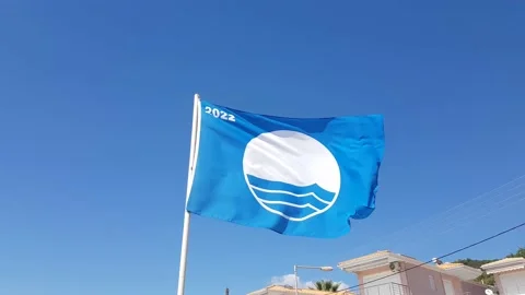 A blue flag on the beach fluttering in the wind Stock Footage 218385777