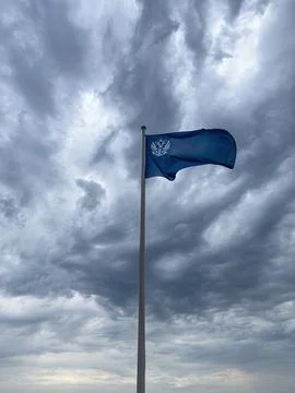 Blue Flag Waving Against a Dramatic Cloudy Sky Photos