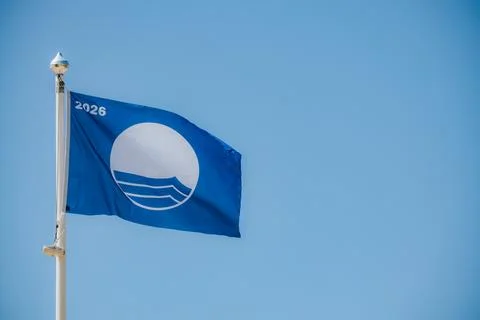 Blue flag with a white circle and wave design, featuring the year 2026, fly.. Stock Photos