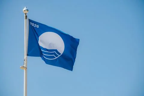 Blue flag with a white circle and waves, featuring the year 2026, flutterin.. Stock Photos