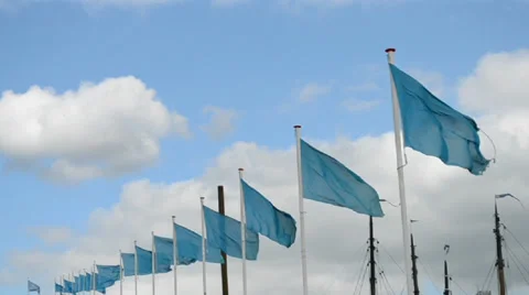 Blue flags line on blue sky with white clouds, Видео 32451915