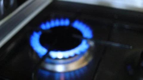 The blue flame of a gas burner on a kitchen stove is out of focus and blurred in Stock Footage 337251171