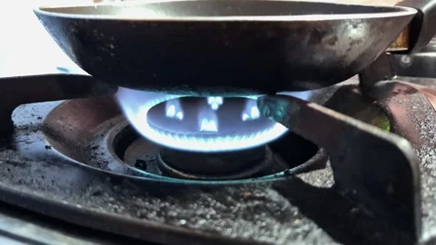 A blue flame heats a frying pan on a gas stove Stock Footage 337512687