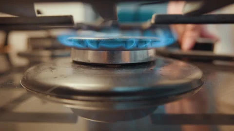 Blue flame lights burner. Professional chef ignites gas stove flames quickly Stock Footage 337469370