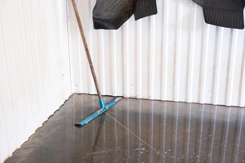 Blue floor squeegee on wet concrete floor at car wash station Stock Photos