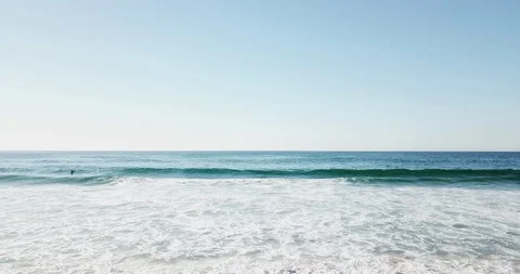 Blue foam wave rolls on to the deserted shore of the ocean Stock Footage 130168475
