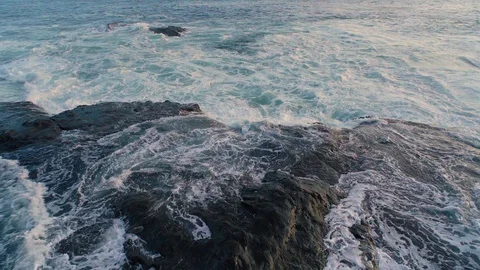 Blue Foaming Waves Ocean Crashing against a Reef Rock Outcrop in Shallow 스톡 동영상 128947253