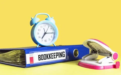 Blue folder with the words BOOKKEEPING on a yellow background with a stapler  Stock Photos