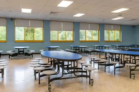 Blue folding table with attached seats in a school cafeteria. Foto stock