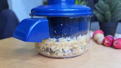 Blue Food Processor Chopping Apples and Potatoes on Wooden Kitchen Table Stock Footage 325832288