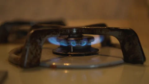 Blue Gas Flame Burning on Rusty Stove Burner in Dark Kitchen Stock Footage 348607153