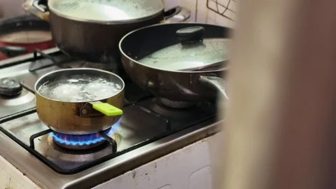 Blue gas flame heating pot on stove Видео 334720622
