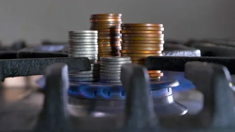 A blue gas hob flame burning around stacks of coins. Stock Footage 170258334