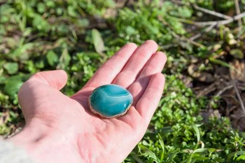 Blue gemstone in hand Stock Photos