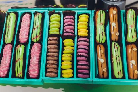 Blue gift box with eclairs and macaroon. Fotos de archivo