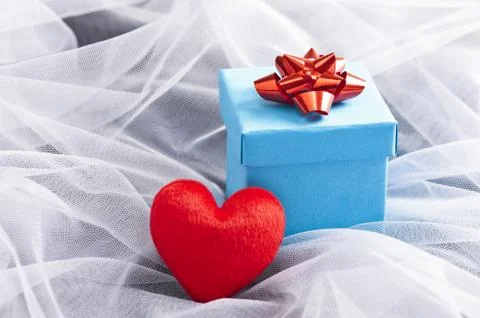 Blue gift box with red bow on wedding veil Stock Photos