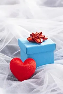 Blue gift box with red bow on wedding veil Stock Photos