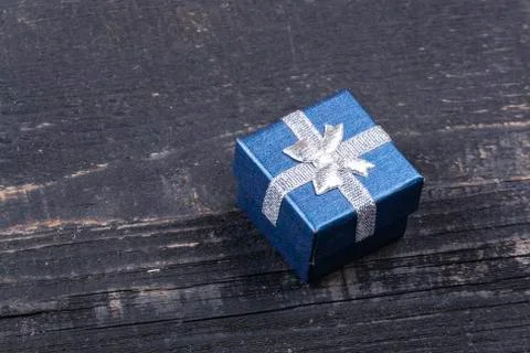 Blue gift box with a silver bow on a wooden background Stock Photos