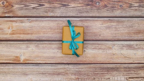 Blue gift boxes with blue ribbons changing quickly on wooden table - Stop motion Stock Footage 123099898