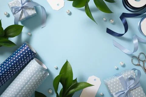Blue gift wrapping frame flat lay with polka dot paper, ribbons, wrapped boxe 库存照片