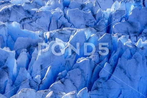Blue glacial ice is exposed in crevasses on Hole in the Wall Glacier, Juneau Ice Stock Photos
