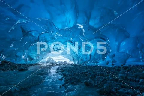 Blue glacial ice is exposed inside an ice cave at the terminus of Mendenhall Gla Stock Photos