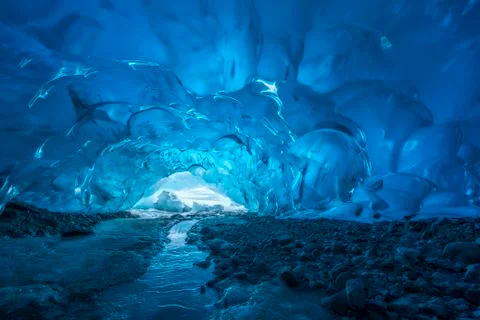Blue glacial ice is exposed inside an ice cave at the terminus of Mendenhall Gla Stock Photos