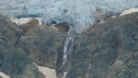 A blue glacier with cracks and waterstream, in rocky mountains. travel and hikin Stock Footage 284867553