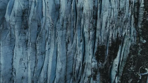 Blue glacier ice surface with dark crevasses and textured patterns in Norway Stock Footage 331966413