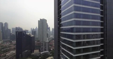 Blue glass tower corner above the Jakarta rooftop sprawl Vídeo Stock 70029974