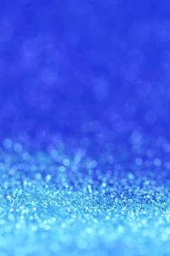 Blue glitter background with light blue shining bokeh.panton classic blue. Stock Photos