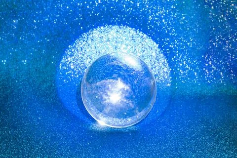 Blue glitter reflections thru a lens ball, on deep blue defocused  backgrou.. Stock Photos