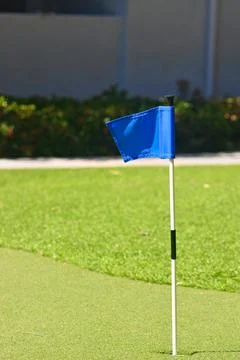 Blue golf practice flag positioned on a putting green Stock Photos