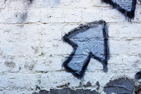 Blue graffiti arrow on a whitewashed brick wall Blue graffiti arrow on a w... Stock Photos