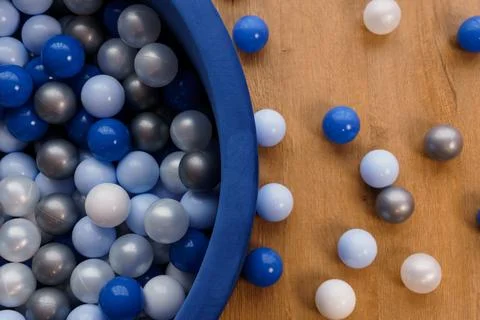 Blue, Gray and White Plastic Balls in Soft Blue Pool on Wooden Surface Stock Photos