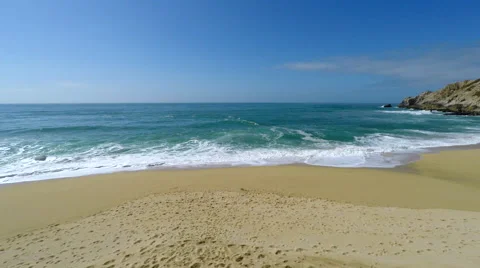 Blue green Pacific ocean shore with waves camera overhead tracking out Stock Footage 62471925