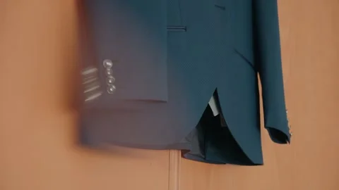 Blue groom suit jacket hanging with soft foreground blur Video stock 327690927