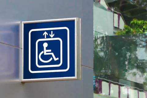 Blue handicap elevator sign with blurred glass background, closeup Stock Photos