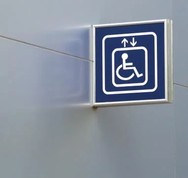 Blue handicap elevator sign on metallic wall, closeup and copy space. Stock Photos