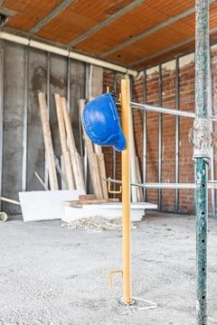 Blue hard hat hanging on construction site scaffolding Stock-Fotos