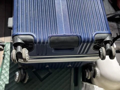 Blue Hard Shell Spinner Suitcase with Double Wheels on Textured Surface Stock Photos