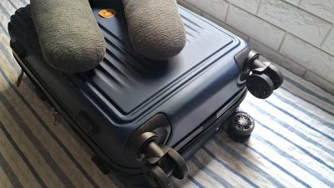 Blue hard shell suitcase with a soft neck pillow for travel Stock-Fotos