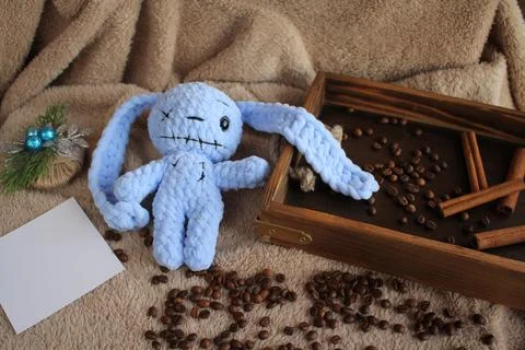 The blue hare lies on a table on a plush blanket. There is a wish card next to Stock Photos