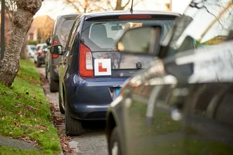 Blue Hatchback Car with Learner Driver Sign Parked at Side of Road Stock Photos