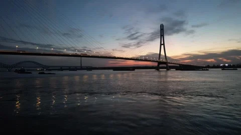 Blue hour aerial view of cable stayed bridge and river traffic in China Stock Footage 337759679